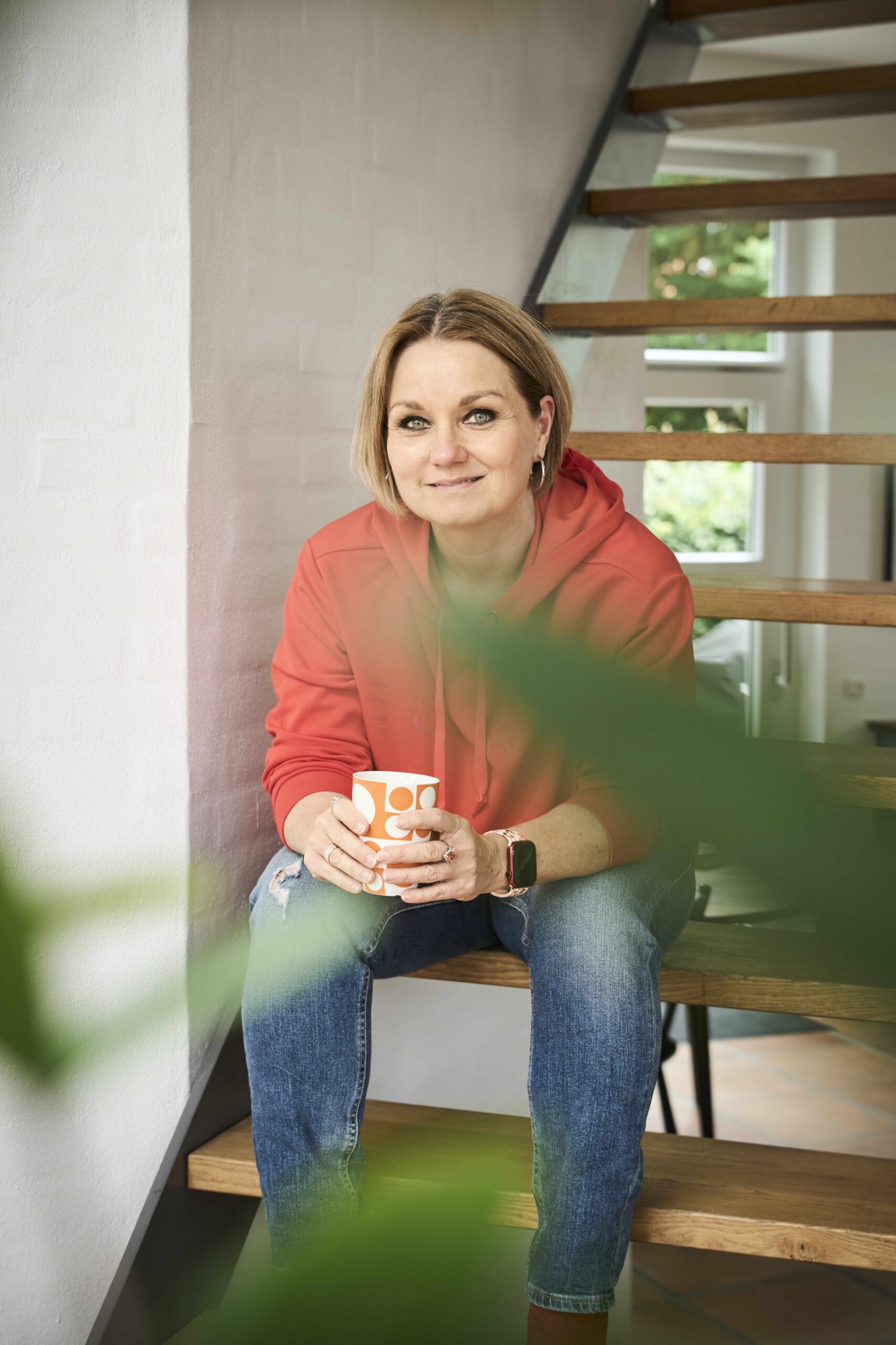 FruSEO sidder på en trappe med en kop kaffe i hånden